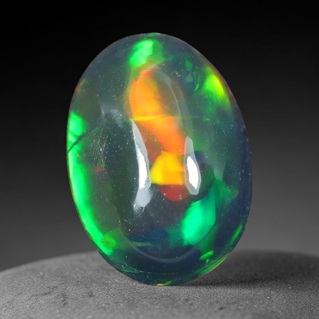 2.12ct Natural Ethiopian Welo Black Smoked Opal Cabochon Loose Gemstone, 80TG: This fully polished Ethiopian Welo opal features a dark smoked base with vivid, sweeping play-of-color shifting across its glossy dome surface, measured at 11.5x8.1x5.0mm. The black smoke treatment de