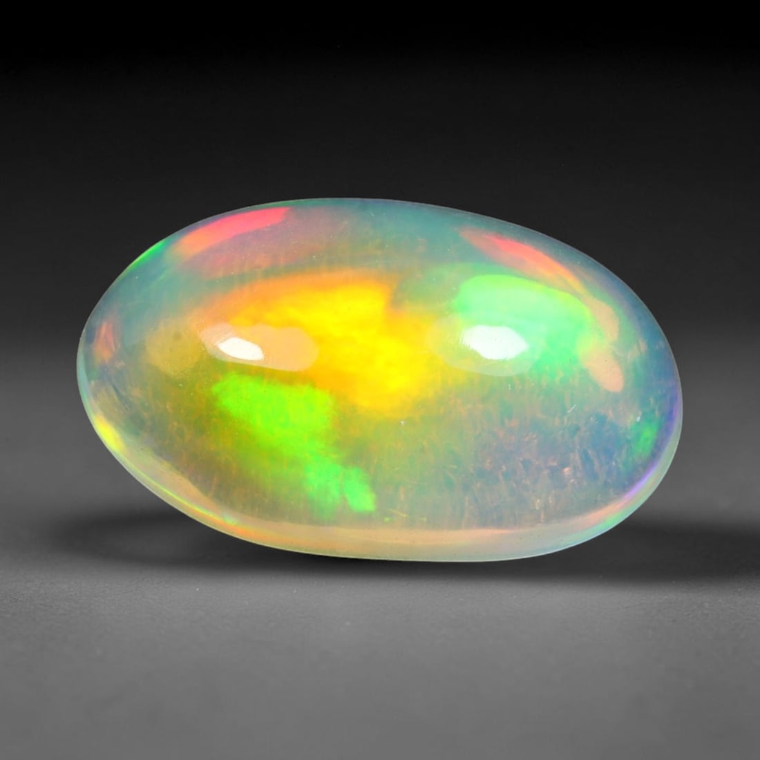3.77ct Natural Ethiopian Welo Solid Opal Oval Cabochon Loose Gemstone, 32TG: Solid opal cabochon mined from Ethiopia's Welo opal deposits, polished into a smooth elongated oval dome with high reflective gloss. The translucent pale milky base hosts broad shifting play-of-color 
