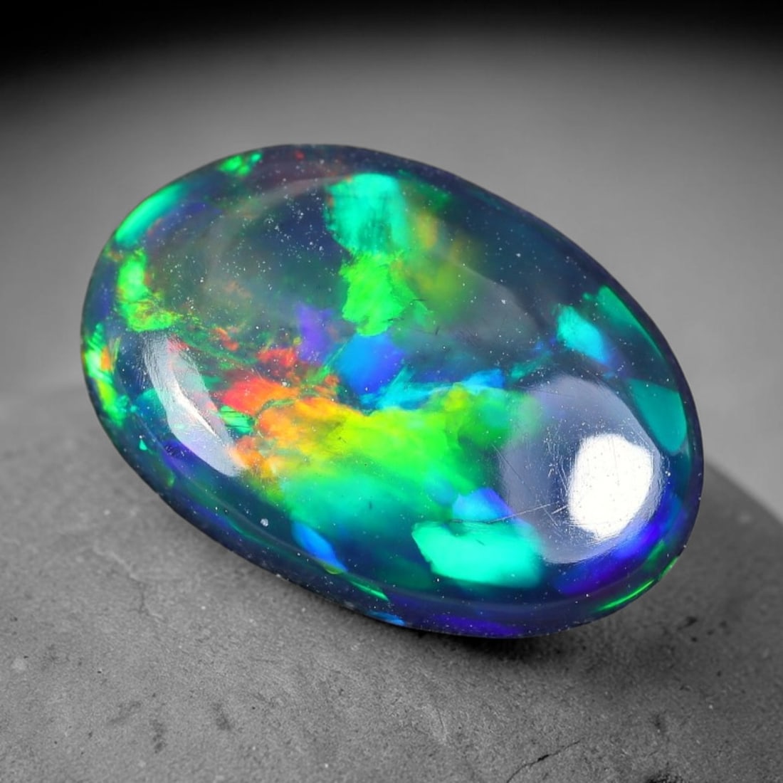 1.53ct Natural Ethiopian Welo Black Smoked Opal Cabochon Loose Gemstone, 70TG: This fully polished Ethiopian Welo opal features a dark smoked base with vivid, sweeping play-of-color shifting across its glossy dome surface, measured at 12.0x8.2x3.2mm. The black smoke treatment de
