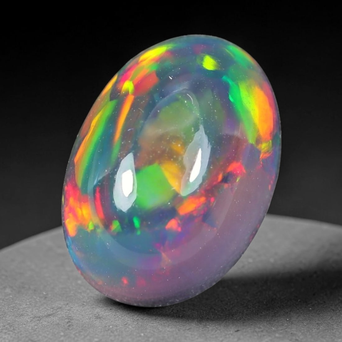2.12ct Natural Ethiopian Welo Black Smoked Opal Cabochon Loose Gemstone, 74TG: This fully polished Ethiopian Welo opal features a dark smoked base with vivid, sweeping play-of-color shifting across its glossy dome surface, measured at 11.0x7.9x5.8mm. The black smoke treatment de