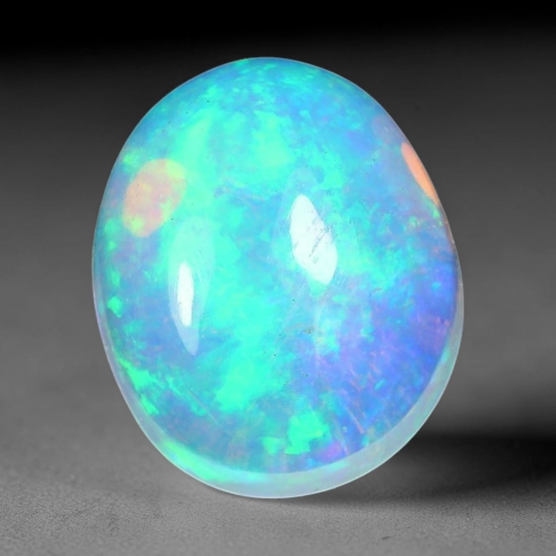 1.95ct Natural Ethiopian Welo Solid Opal Oval Cabochon Loose Gemstone, 52TG: Solid opal cabochon mined from Ethiopia's Welo opal deposits, polished into a smooth elongated oval dome with high reflective gloss. The translucent pale milky base hosts broad shifting play-of-color 