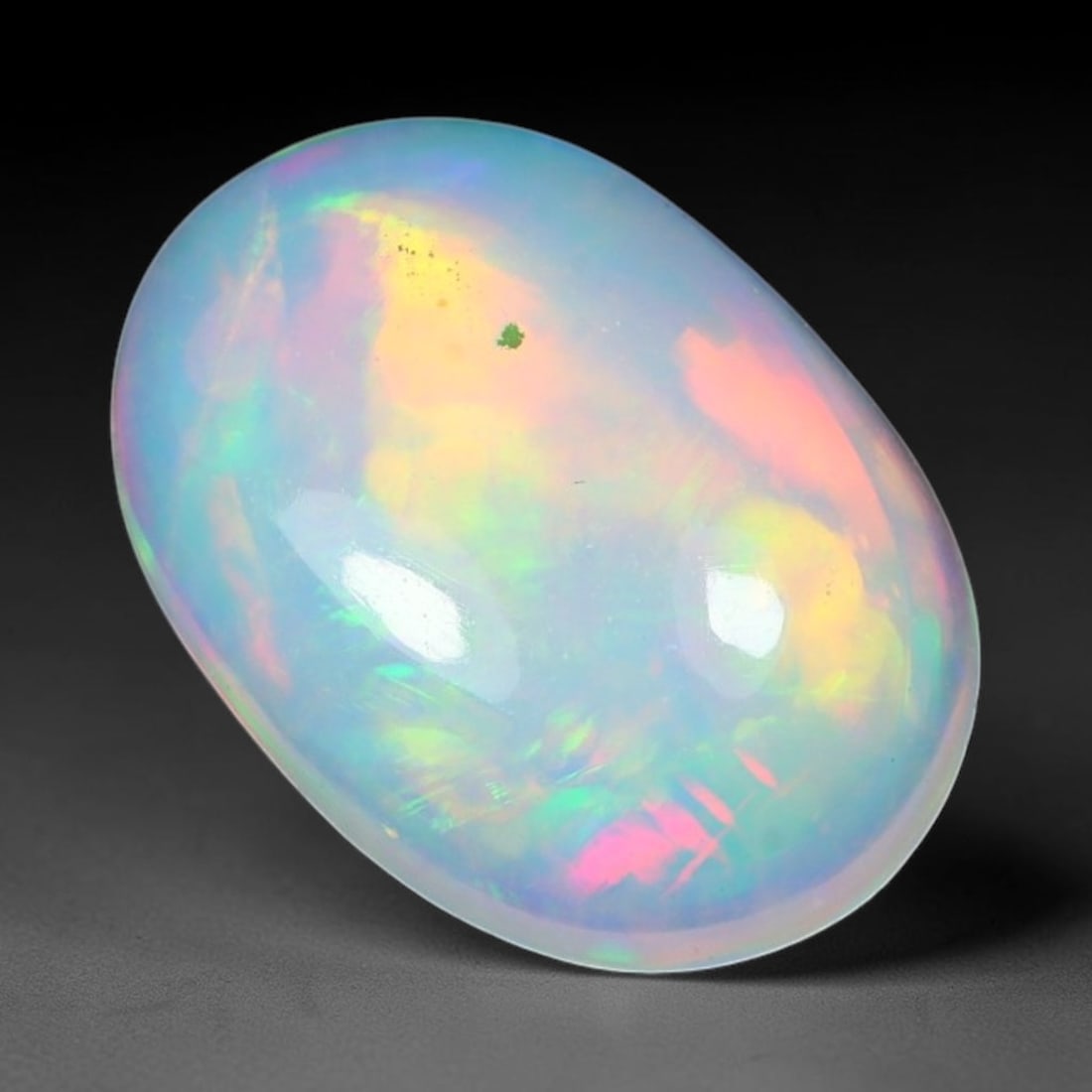 1.67ct Natural Ethiopian Welo Solid Opal Oval Cabochon Loose Gemstone, 50TG: Solid opal cabochon mined from Ethiopia's Welo opal deposits, polished into a smooth elongated oval dome with high reflective gloss. The translucent pale milky base hosts broad shifting play-of-color 