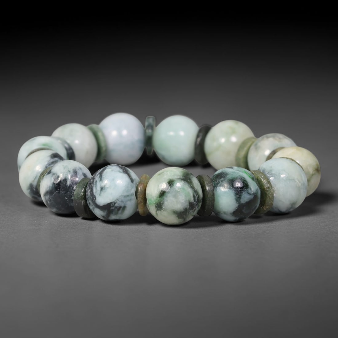 Natural Burmese Type A Dark Mottled Floating Green Jadeite Jade Round Bead Bracelet, 77TK: Polished from natural Burmese Type A jadeite, this bracelet features smooth round dark mottled floating green beads measuring 13.6mm, paired with matching jadeite spacer discs. It has milky white base