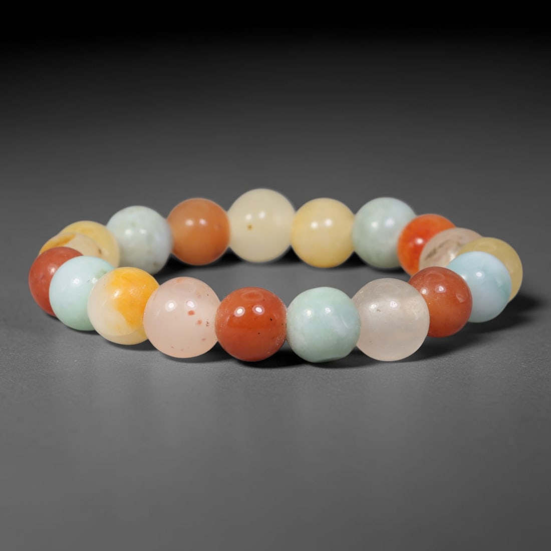 Natural Burmese Type A Jadeite Jade Multicolour Round Bead Bracelet, 87TK: Polished from natural Burmese Type A jadeite, this bracelet features smooth round multicolour beads measuring 11.6mm. It showcases a vibrant mix of warm red, peach, golden yellow and soft pale cyan to