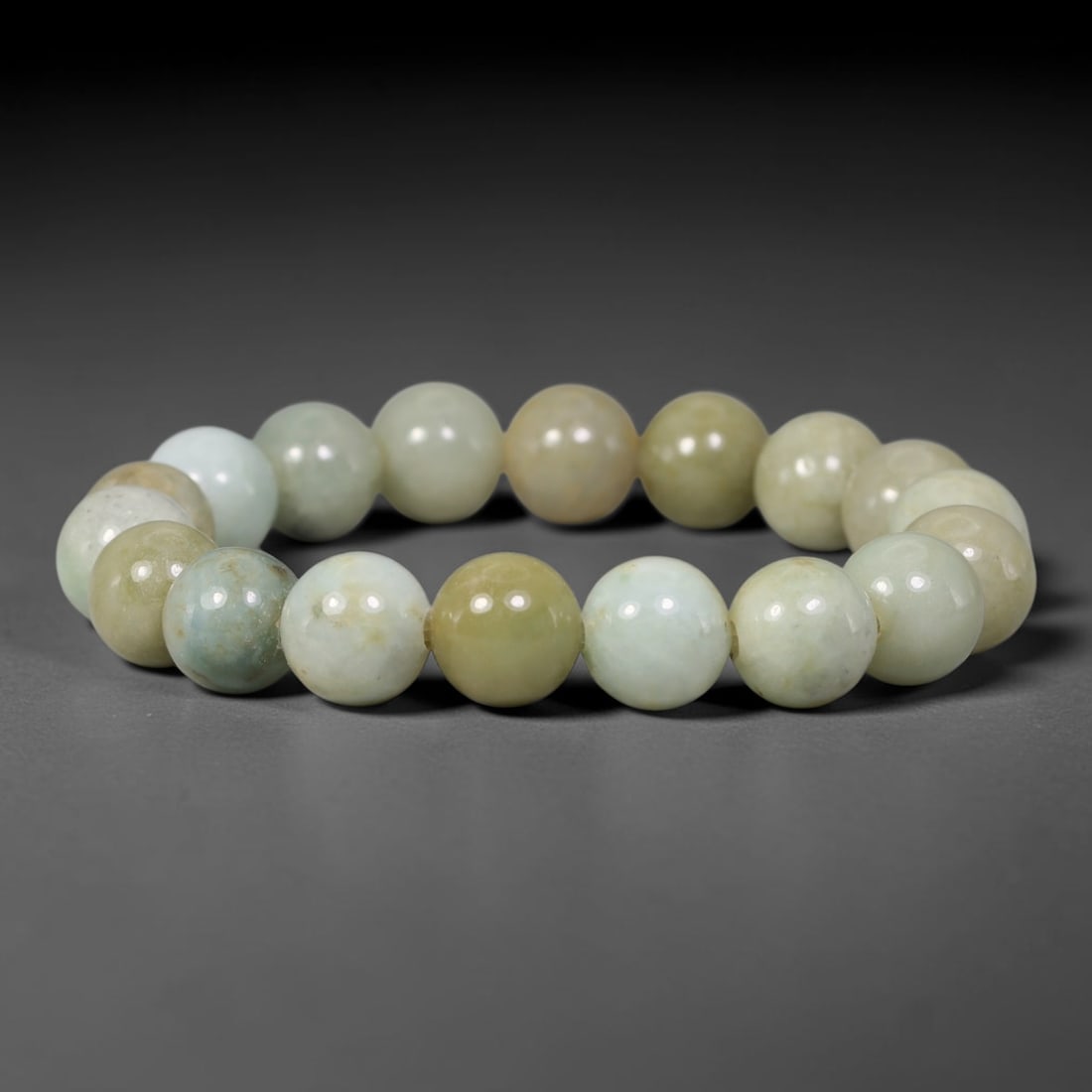 Natural Burmese Type A Pale Celadon Mottled Jadeite Jade Round Bead Bracelet, 79TK: Polished from natural Burmese Type A jadeite, this bracelet features smooth round pale celadon mottled beads measuring 11.2mm. It blends soft pale celadon, milky white and warm honey-yellow tones with