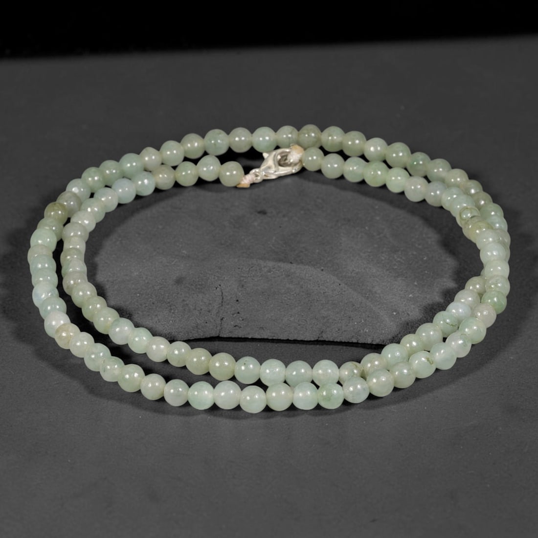 Natural Burmese Type A Pale Celadon Jadeite Jade Bead Necklace, 9TF: Smooth round natural Burmese Type A jadeite beads measuring 5.7mm, exhibiting soft pale celadon green with gentle natural tonal variations across the strand. Completed with a sterling silver lobster c