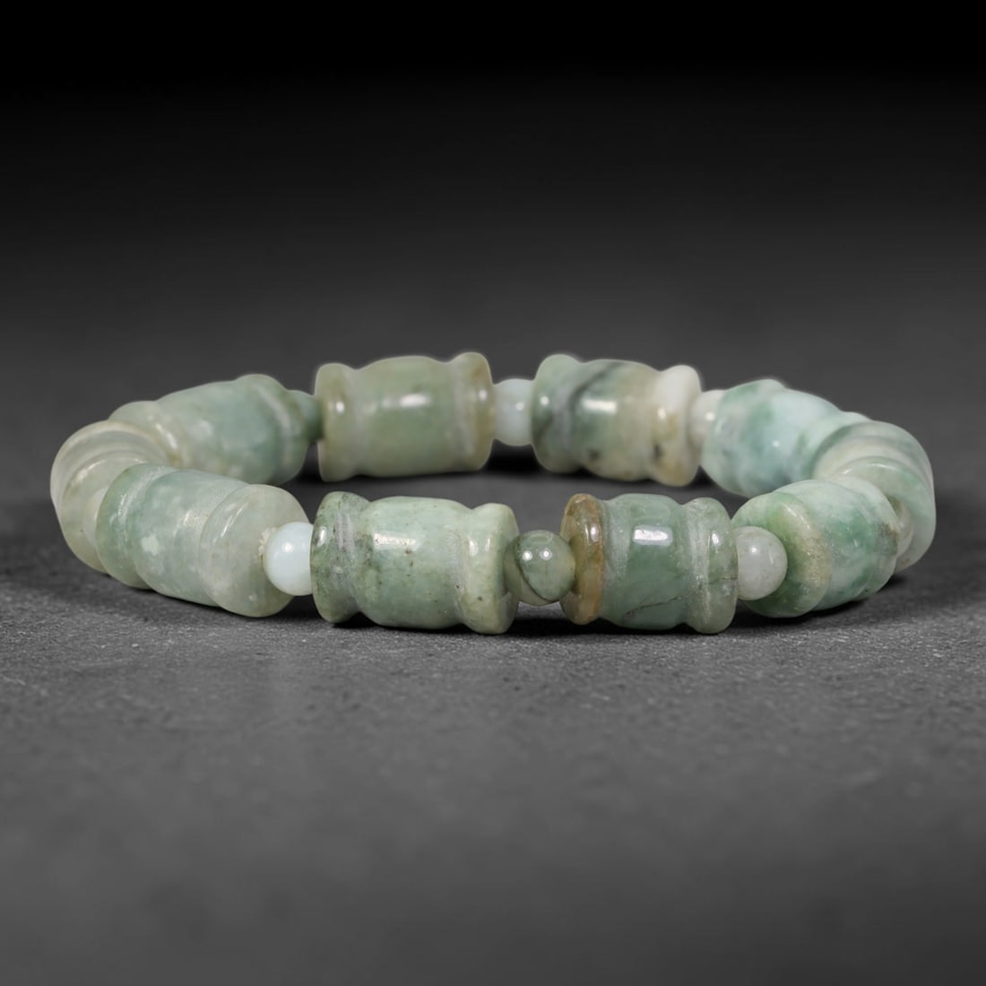 Natural Burmese Type A Mottled Celadon Barrel Shape Jadeite Jade Bead Bracelet, 76TK: Polished from natural Burmese Type A jadeite, this bracelet features carved mottled celadon barrel shape beads measuring 11.7mm, separated by small round jadeite spacer beads. It displays soft celadon