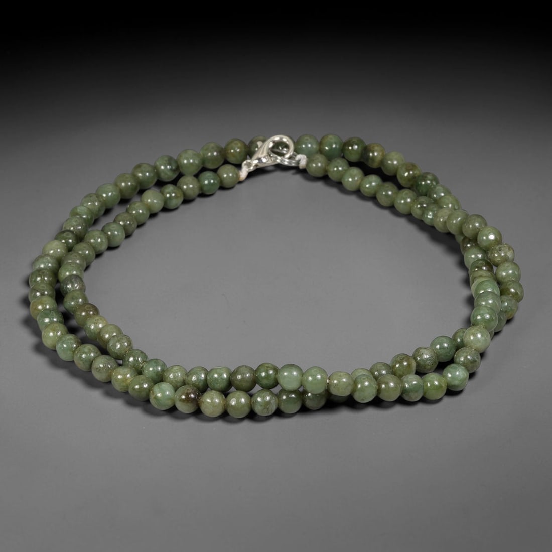 Natural Burmese Type A Green Mottled Jadeite Jade Beaded Necklace, 18TF: Smooth round natural Burmese Type A jadeite beads measuring 5.7mm, displaying blended muted forest green tones with subtle natural colour variations across the strand. Finished with a sterling silver 