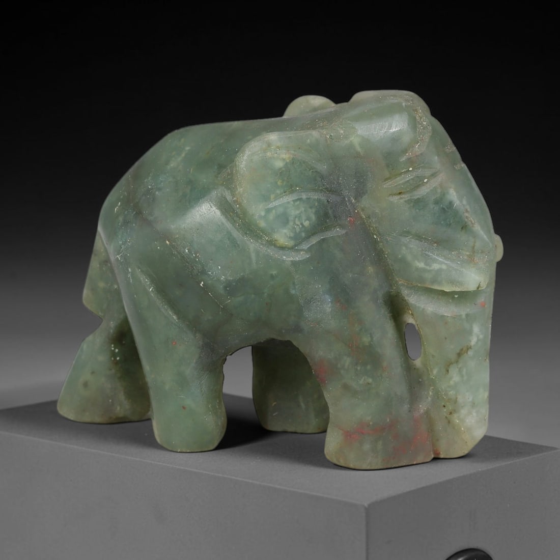 Natural Burmese Type A Green Jadeite Jade Elephant Carving, 2TC: Hand-carved from natural Burmese Type A jadeite, this elephant figurine measures 49x27mm. It features soft muted green tones with natural veining, faint pale mottling and subtle reddish mineral flecks