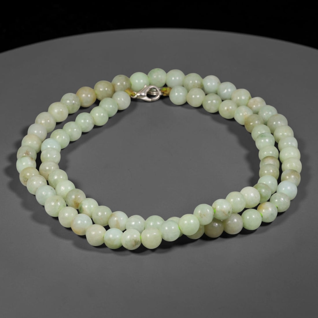 Natural Burmese Type A Pale Celadon Jadeite Jade Round Bead Necklace, 36TF: Polished from natural Burmese Type A jadeite, this necklace features smooth round pale celadon jadeite beads measuring 7.5mm, secured with a metal lobster clasp. It carries soft pale celadon and faint