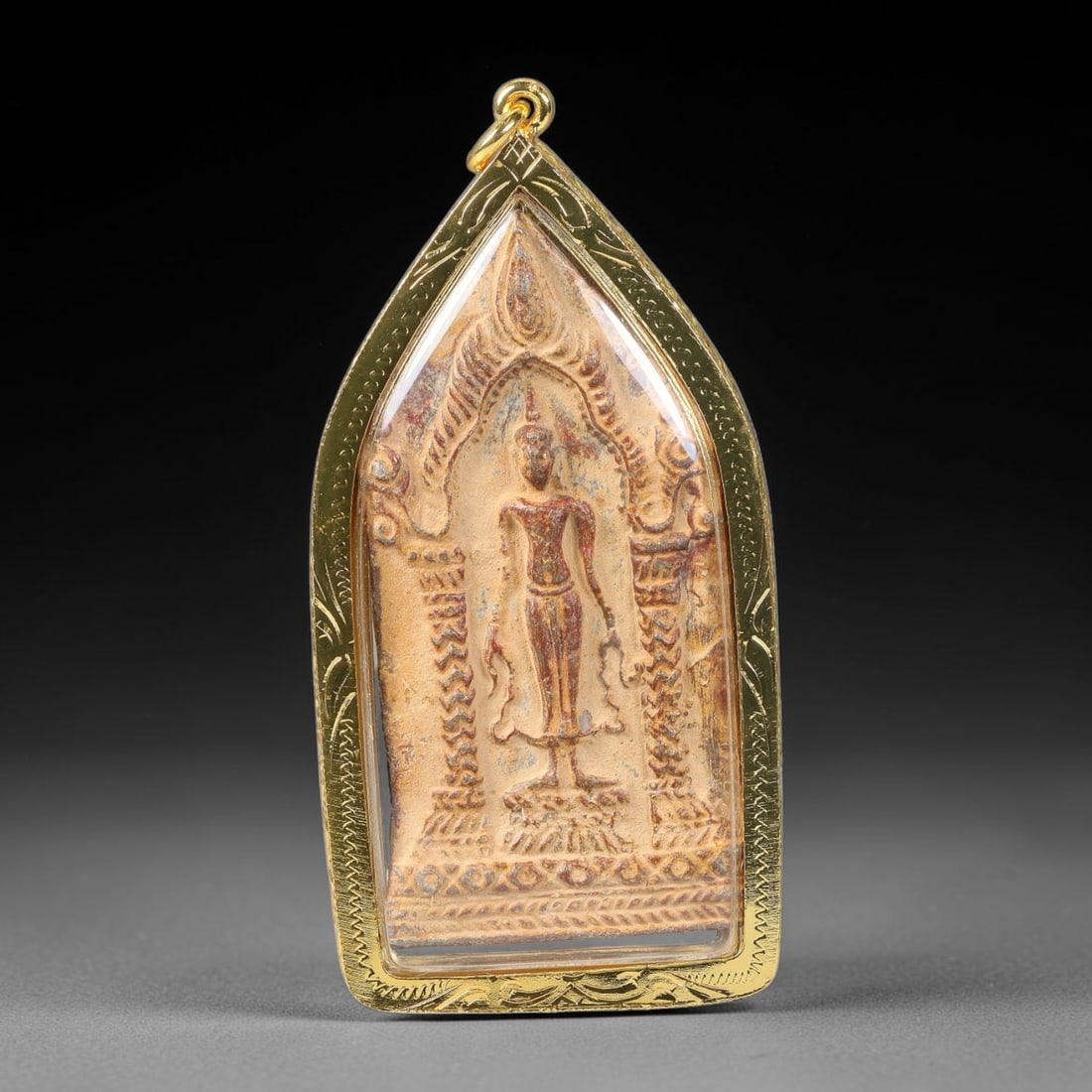 Thai Clay Standing Buddha Amulet - Gold Cased Votive Pendant, 7YY: Hand-molded clay devotional piece displaying standing Buddha relief set within pointed temple arch framing with patterned pillar and border detailing following Thai votive craft traditions. The clay s