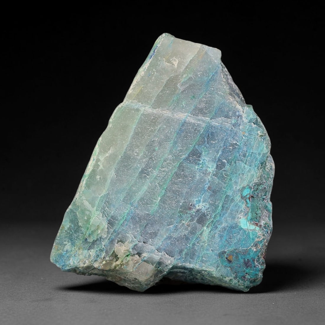 86ct Natural Peruvian Chrysocolla Polished Slab Rough, 61WV: This partial-polished chrysocolla slab features blended mineral matrix with smooth refined face and unaltered natural rugged edge across its 35x30x9mm elongated form, translucent mineral layers hold s