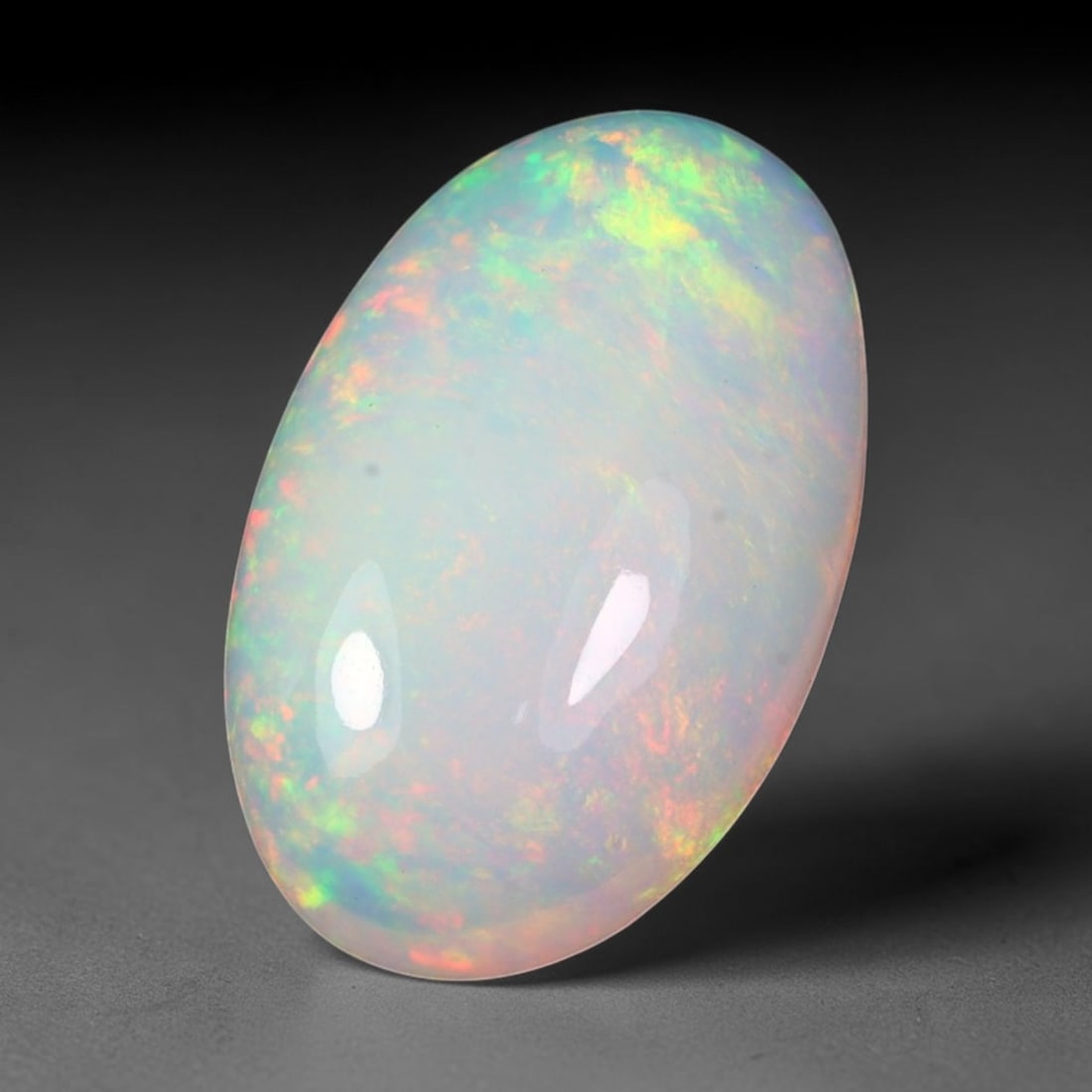 5.75ct Natural Ethiopian Welo Solid Opal Oval Cabochon Loose Gemstone, 22TG: Solid opal cabochon mined from Ethiopia's Welo opal deposits, polished to a sleek elongated oval domed cut with uniform high-gloss surface finish. The pale translucent milky base features scattered pa