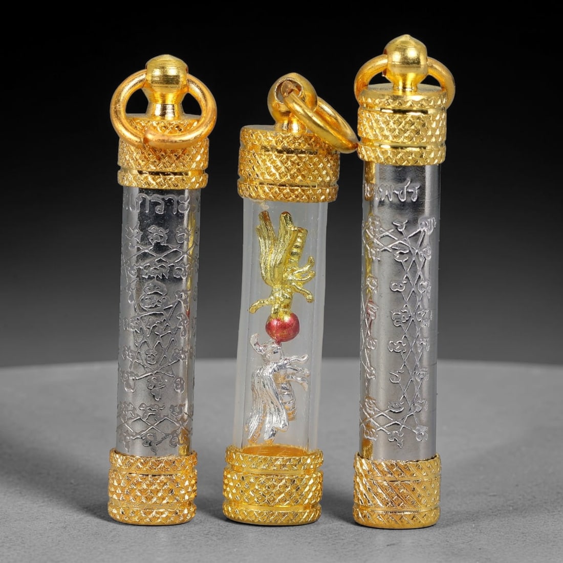 Set of 3 Thai Engraved Silver & Gold Takrut Tube Amulet Pendants, 26YY: Collection of three cylindrical takrut tube spiritual pendants, crafted with dual-tone silver engraved tube bodies and textured diamond-pattern gold caps fitted with double loop gold hanging rings. Tw