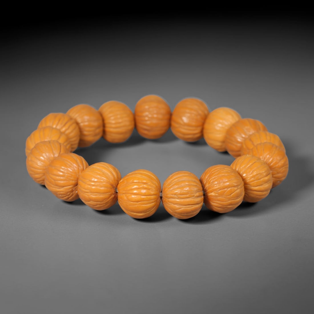 Rudraksha Seed Bracelet - Carved Buddhist Prayer Bead Strand, 64YM: This strand is constructed from naturally textured rudraksha seed beads, shaped into uniform barrel forms with intricate organic fissuring across each surface. The seeds display a consistent pale tan 