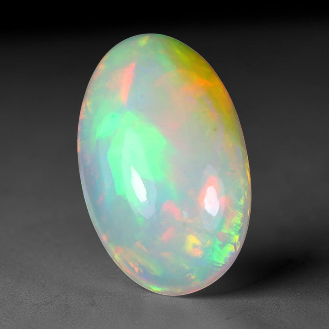 5.57ct Natural Ethiopian Welo Solid Opal Oval Cabochon Loose Gemstone, 13TG: Solid opal cabochon mined from Ethiopia's Welo opal deposits, polished into a smooth elongated oval dome with high reflective gloss. The translucent pale milky base hosts broad shifting play-of-color 