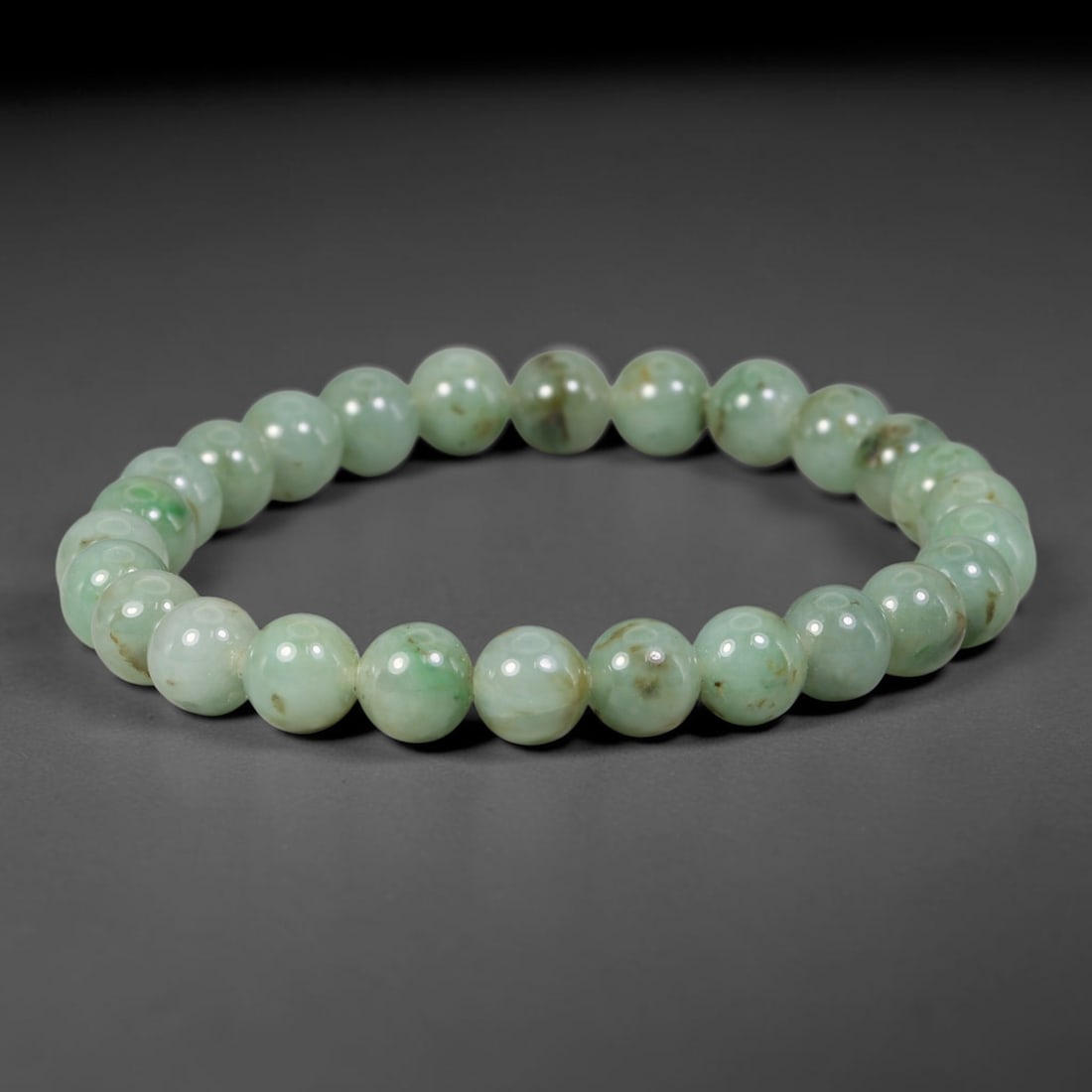 Natural Burmese Type A Green Floating Jadeite Jade Beaded Bracelet, 41WY: Formed from natural untreated Burmese Type A jadeite material, each spherical bead bears naturally dispersed green mineral markings embedded within the stone matrix through geological formation proces