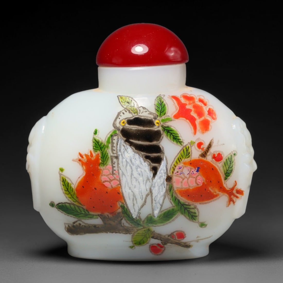 A Chinese Peking Glass Hand Painted Cicada Snuff Bottle, 64WT: The vessel is crafted from smooth opaque white Peking glass with moulded lion head mask handles set upon the rounded shoulder sections. One face features hand painted artwork depicting a cicada restin