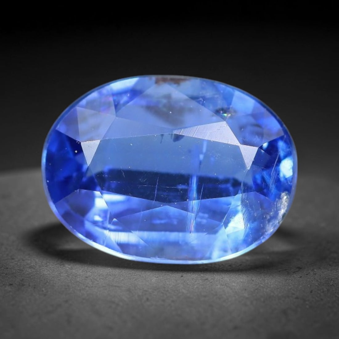 1.80 Carats Natural Brazilian Kyanite Oval Faceted Loose Gemstone, 60XY: This specimen consists of natural kyanite mineral material refined via professional faceted lapidary work, with uniform polished surfaces across the crystal exterior. Natural internal particulate mark