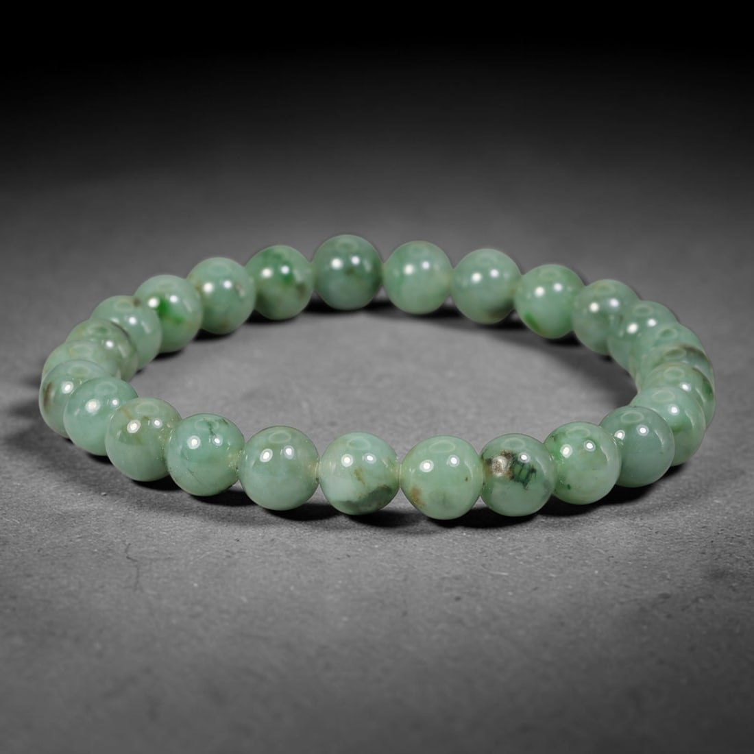 Natural Burmese Type A Green Floating Jadeite Jade Beaded Bracelet, 42WY: Formed from natural untreated Burmese Type A jadeite material, each spherical bead bears naturally dispersed green mineral markings embedded within the stone matrix through geological formation proces