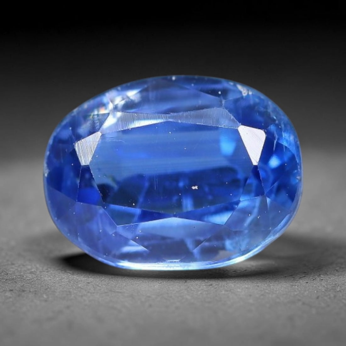 1.60 Carats Natural Brazilian Kyanite Oval Faceted Loose Gemstone, 63XY: This specimen consists of natural kyanite mineral material refined via professional faceted lapidary work, with uniform polished surfaces across the crystal exterior. Natural internal particulate mark
