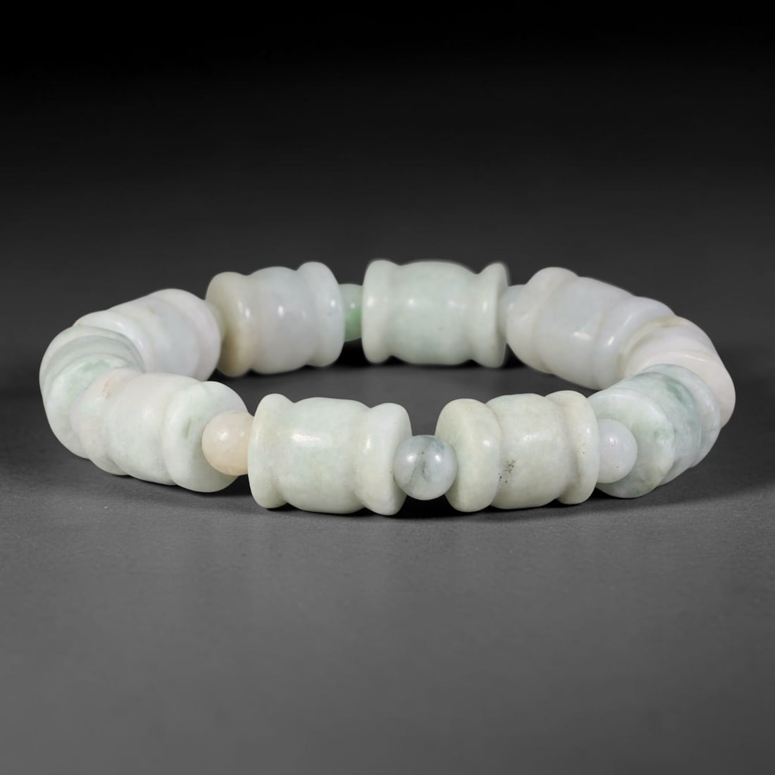 Natural Burmese Type A Carved Waisted Barrel Jadeite Jade Bead Bracelet, 15TP: Strung from natural Type A Burmese jadeite, this bracelet features neatly carved waisted barrel beads with a pale milky white base and faint diffused green clouding. Each sculpted barrel bead is smoot
