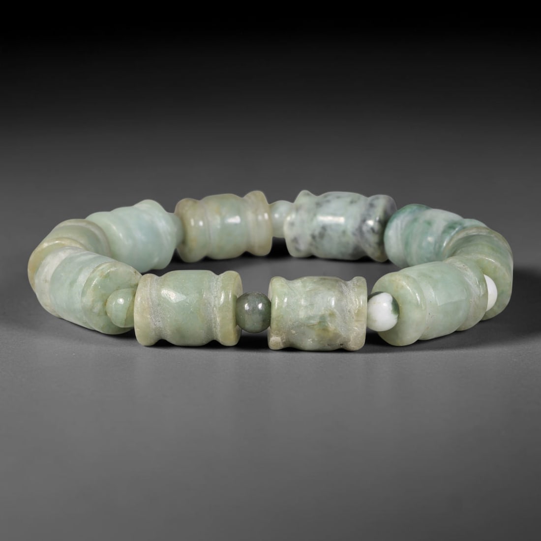 Natural Burmese Type A Carved Barrel Form Jadeite Jade Bead Bracelet, 8TP: Strung from natural Type A Burmese jadeite, this bracelet features uniquely carved waisted barrel-shaped beads in pale celadon green, accented with small round spacer beads of contrasting jadeite tone