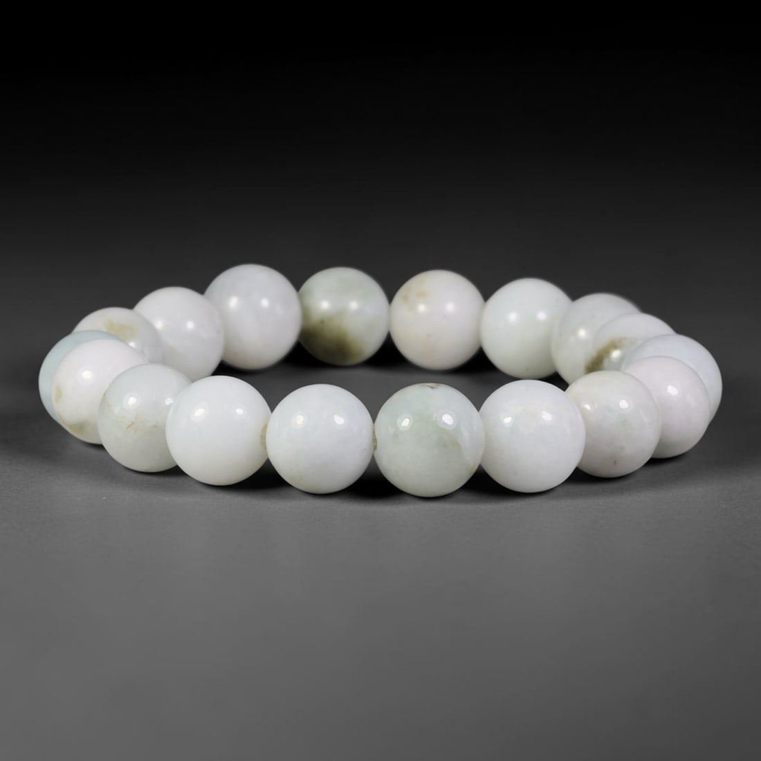 Natural Burmese Type A Milky White Subtle Green Jadeite Jade Bead Bracelet, 4TP: Strung from natural Type A Burmese jadeite, this spherical bead bracelet features a soft milky white base with faint muted green and light mineral flecks scattered throughout. Each bead is smoothly po