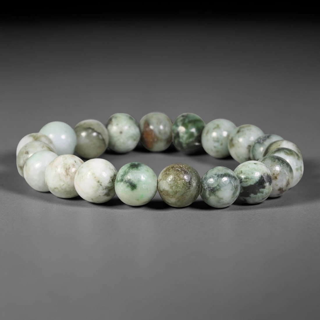 Natural Burmese Type A Mottled Green White Jadeite Jade Bead Bracelet, 96TK: Strung from natural Type A Burmese jadeite, this spherical bead bracelet features a pale white base accented by mottled deep green and subtle earthy brown mineral inclusions across individual beads. E