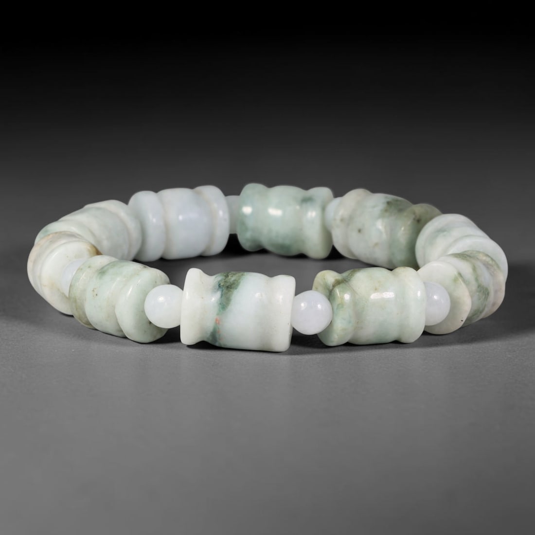 Natural Burmese Type A Carved Waisted Barrel Jadeite Jade Bead Bracelet, 12TP: Strung from natural Type A Burmese jadeite, this bracelet features carved waisted barrel beads set against a pale milky white base with soft floating dark green mottling and thin mineral streaks. Each