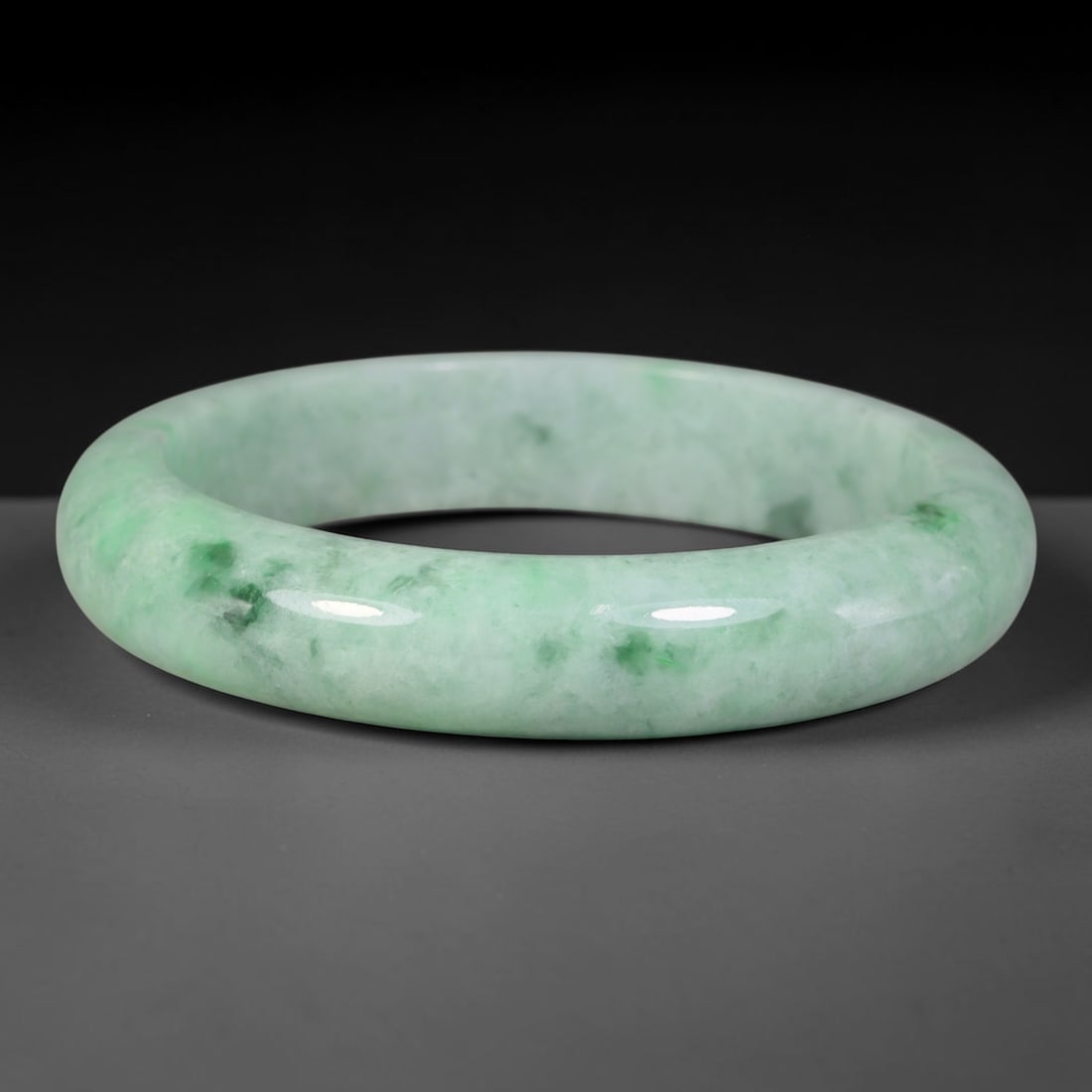 Natural Burmese Type A Floating Spotted Green Jadeite Jade Bangle Bracelet, 79TD: Crafted from natural Type A Burmese jadeite, this substantial thick-profile rounded bangle bears a soft pale green foundation accented by scattered floating vivid green mineral spots throughout the ma