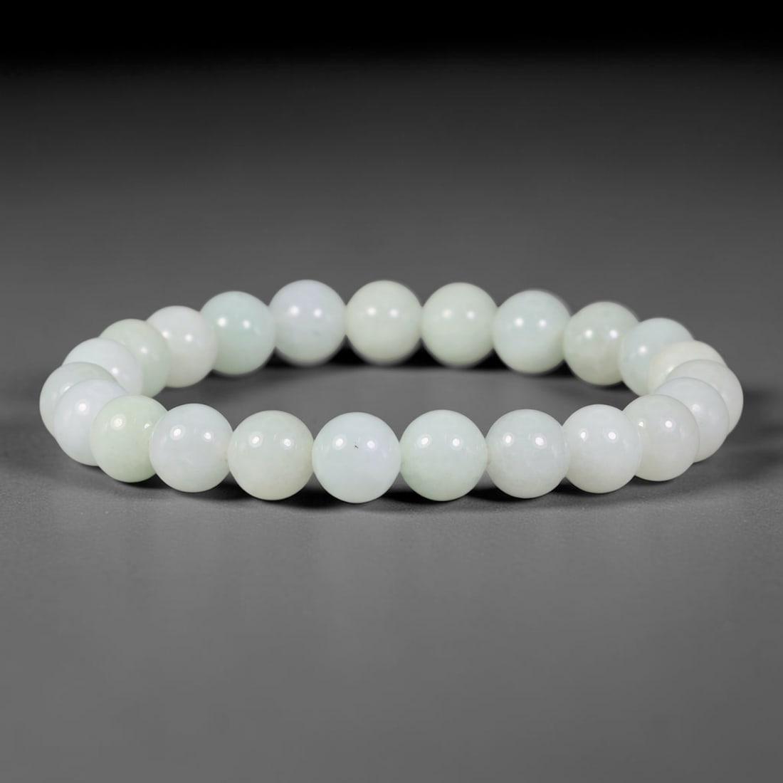 Natural Burmese Type A Pale Milky Celadon Jadeite Jade Bead Bracelet, 26TP: Strung from natural Type A Burmese jadeite, this spherical bead bracelet features a clean pale milky celadon hue with faint, subtle natural clouding across the beads. Each bead is smoothly polished an