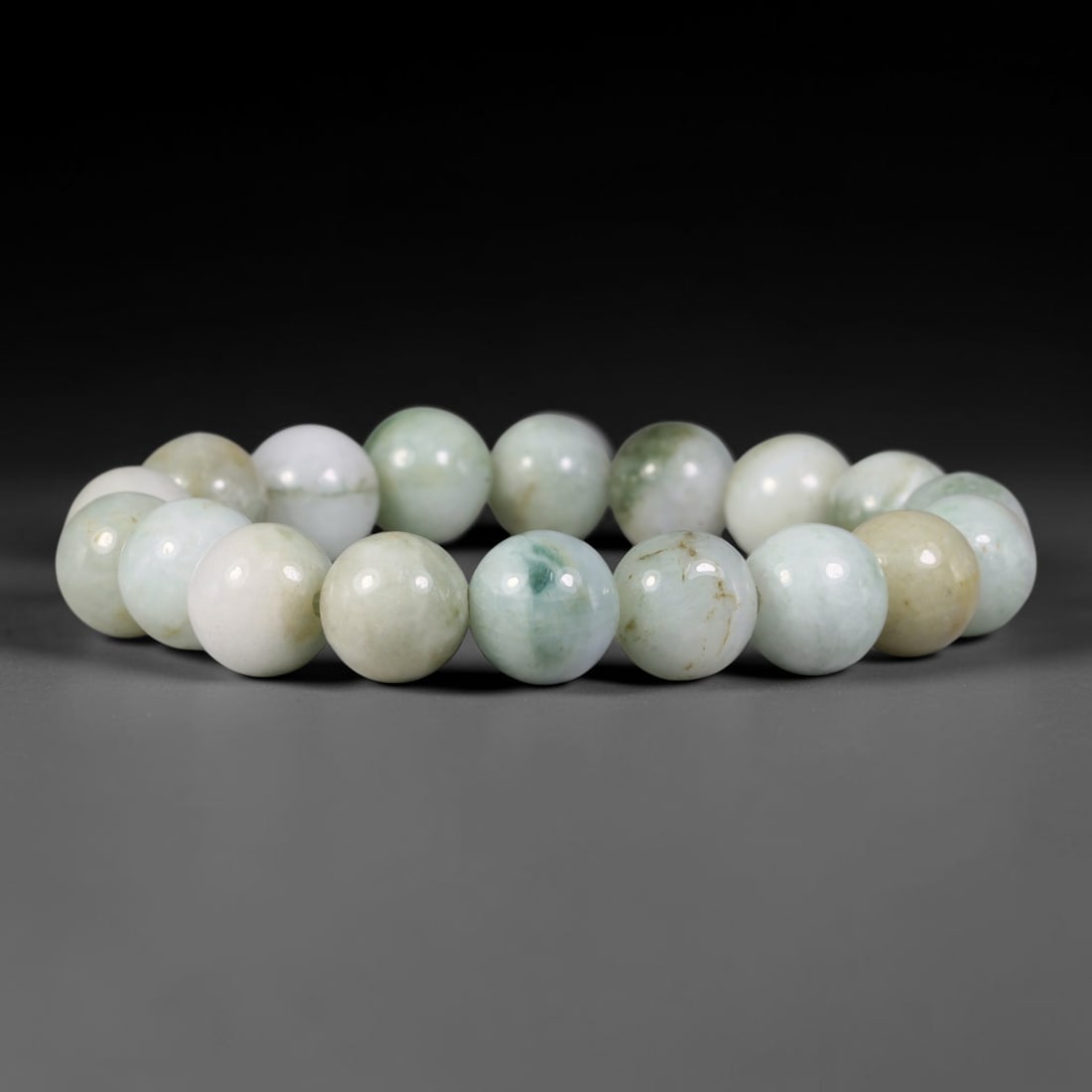 Natural Burmese Type A Pale Celadon Floating Green Jadeite Jade Bead Bracelet, 3TP: Strung from natural Type A Burmese jadeite, this spherical bead bracelet presents gentle pale celadon and creamy off-white hues, accented by delicate floating green flecks and faint warm mineral fissu