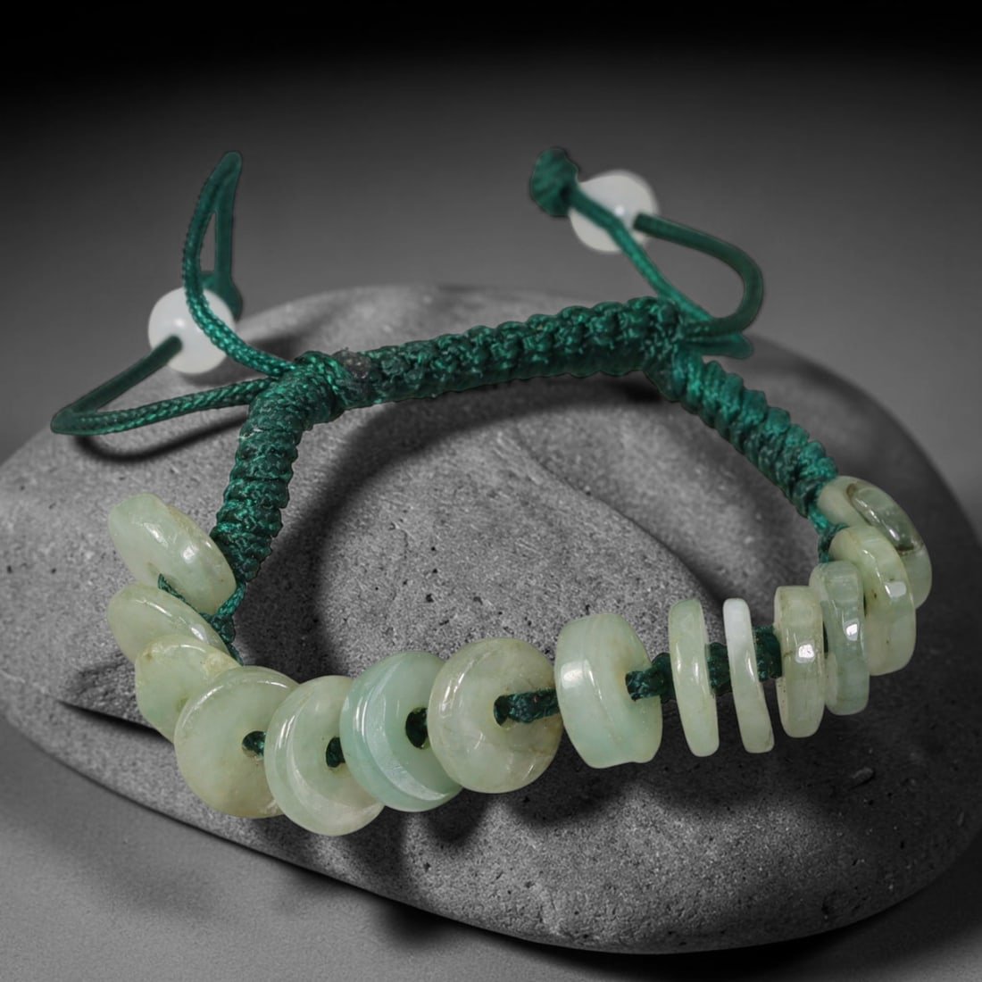 Natural Burmese Type A Pale Celadon Donut Jadeite Adjustable Braided Cord Bracelet, 17TP: Handcrafted adjustable braided dark green cord bracelet, strung with natural Type A Burmese jadeite donut beads in soft pale celadon tone. The flat disc beads carry subtle natural tonal variations and