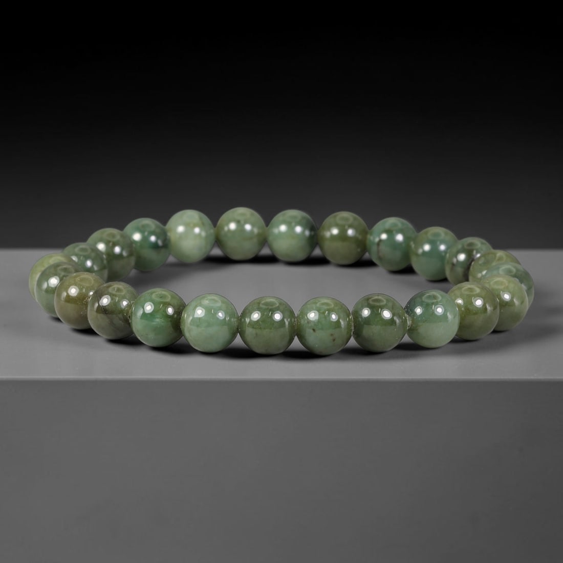 Natural Burmese Type A Muted Olive Green Jadeite Jade Bead Bracelet, 27TP: Strung from natural Type A Burmese jadeite, this spherical bead bracelet carries soft muted olive green tones with subtle natural mineral streaks and faint tonal shifts across the beads. Each bead is 