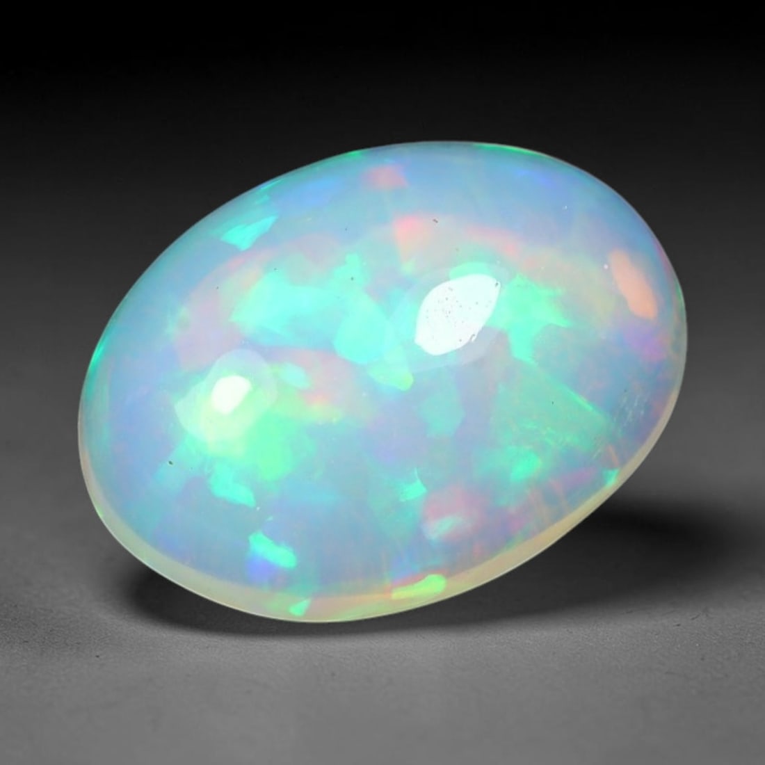 1.99ct Natural Ethiopian Welo Solid Opal Oval Cabochon Loose Gemstone, 43TG: Solid opal cabochon mined from Ethiopia's Welo opal deposits, polished into a smooth elongated oval dome with high reflective gloss. The translucent pale milky base hosts broad shifting play-of-color 