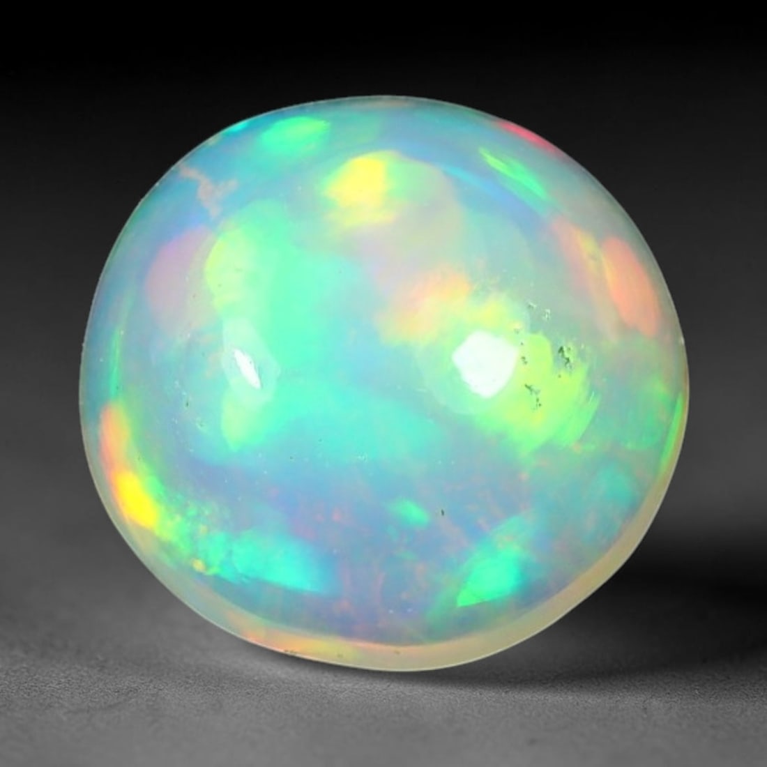 1.52ct Natural Ethiopian Welo Solid Opal Oval Cabochon Loose Gemstone, 55TG: Solid opal cabochon mined from Ethiopia's Welo opal deposits, polished into a smooth elongated oval dome with high reflective gloss. The translucent pale milky base hosts broad shifting play-of-color 