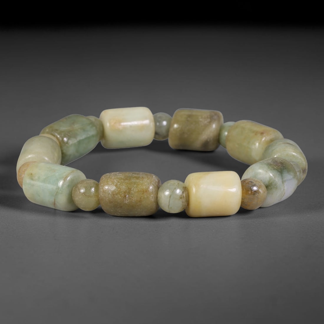Natural Burmese Type A Multi-Tone Jadeite Jade Barrel Beaded Bracelet, 7TA: Crafted from untreated natural Burmese Type A jadeite jade beads with maximum bead dimension of 10.85mm, this wearable strand features a gentle polished finish displaying layered natural earthy minera
