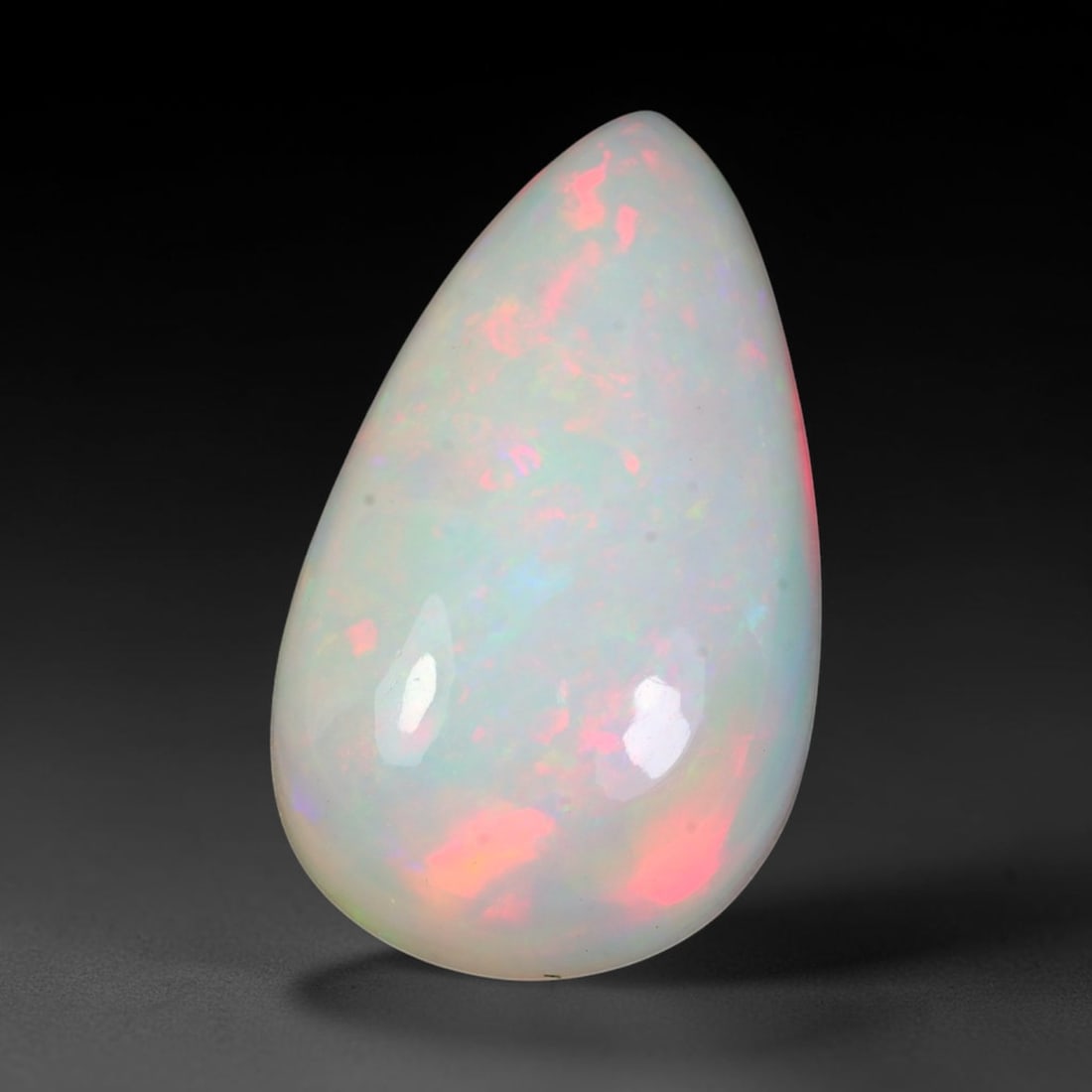 9.37ct Natural Ethiopian Welo Solid Opal Pear Cabochon Loose Gemstone, 21TG: Solid opal cabochon mined from Ethiopia's Welo opal deposits, shaped into a well-proportioned pear teardrop dome with smooth mirror gloss across the entire surface. The pale translucent milky base hol