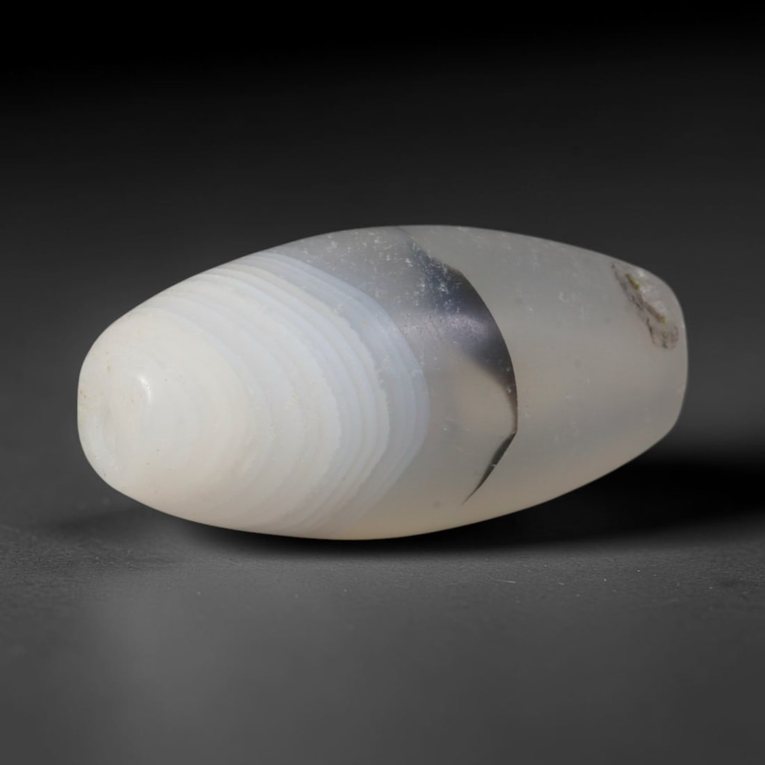 Ancient Sogdian Central Asian Banded Agate Bicone Trade Bead (500-1000 CE), 1XV: This antique banded agate bicone bead originates from Sogdian merchant civilizations, the renowned caravan traders of Central Asia who produced distinct patterned chalcedony beads to trade across Chin