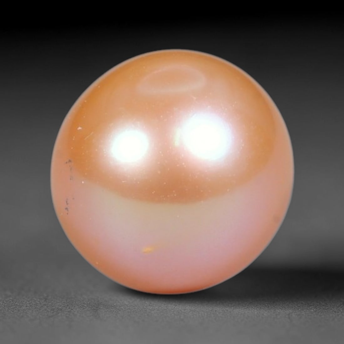 3.70ct Natural Round Freshwater Peach Pink Pearl Loose Gemstone 8.0mm, 46XZ: Flawless natural undrilled round freshwater pearl, showcasing a smooth symmetrical spherical form with soft gradient peach blush nacre transitioning from warm apricot crown to pale pink base. The pear