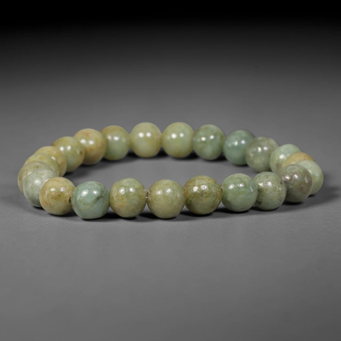 Natural Burmese Type A Mottled Celadon Jadeite Jade Round Bead Bracelet, 90TK: Polished from natural Burmese Type A jadeite, this bracelet features smooth round mottled celadon beads measuring 8.7mm. It displays blended celadon green and warm earthy yellowish-brown mottling with