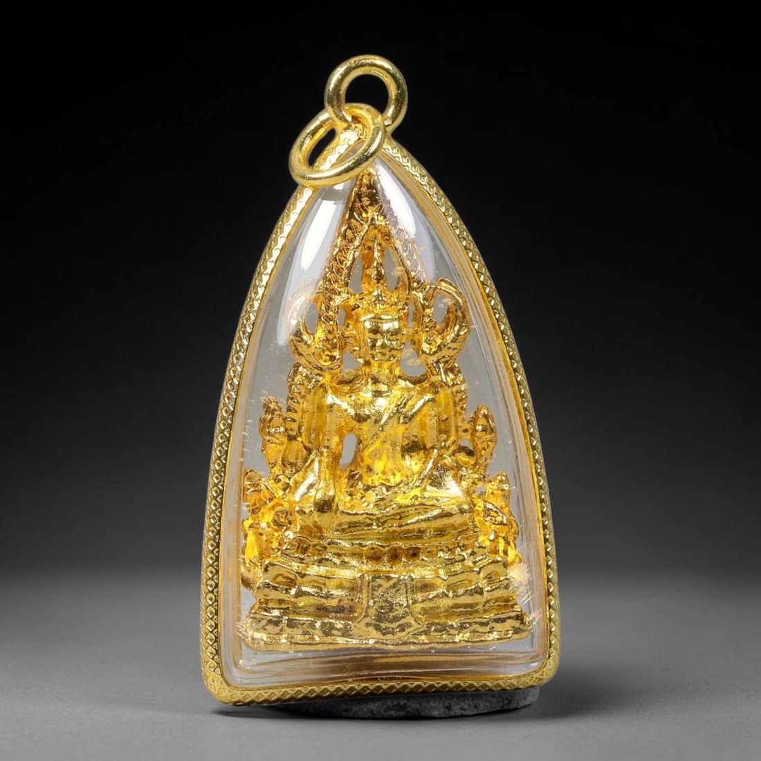 Thai Gold Plated Phra Chinnarat Buddha Amulet Pendant With Clear Protective Casing, 67YY: Teardrop triangular gold plated textured frame amulet measuring 4.0x2.3cm, equipped with double gold jump rings for easy necklace attachment. A transparent clear cover fully protects the intricate gol