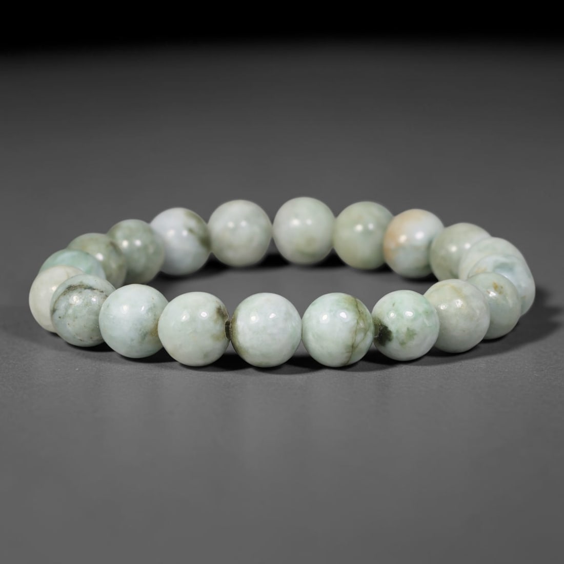 Natural Burmese Type A Pale Celadon Mottled Jadeite Jade Round Bead Bracelet, 85TK: Polished from natural Burmese Type A jadeite, this bracelet features smooth round pale celadon mottled beads measuring 10.6mm. It displays soft pale celadon and milky white bases accented by natural d