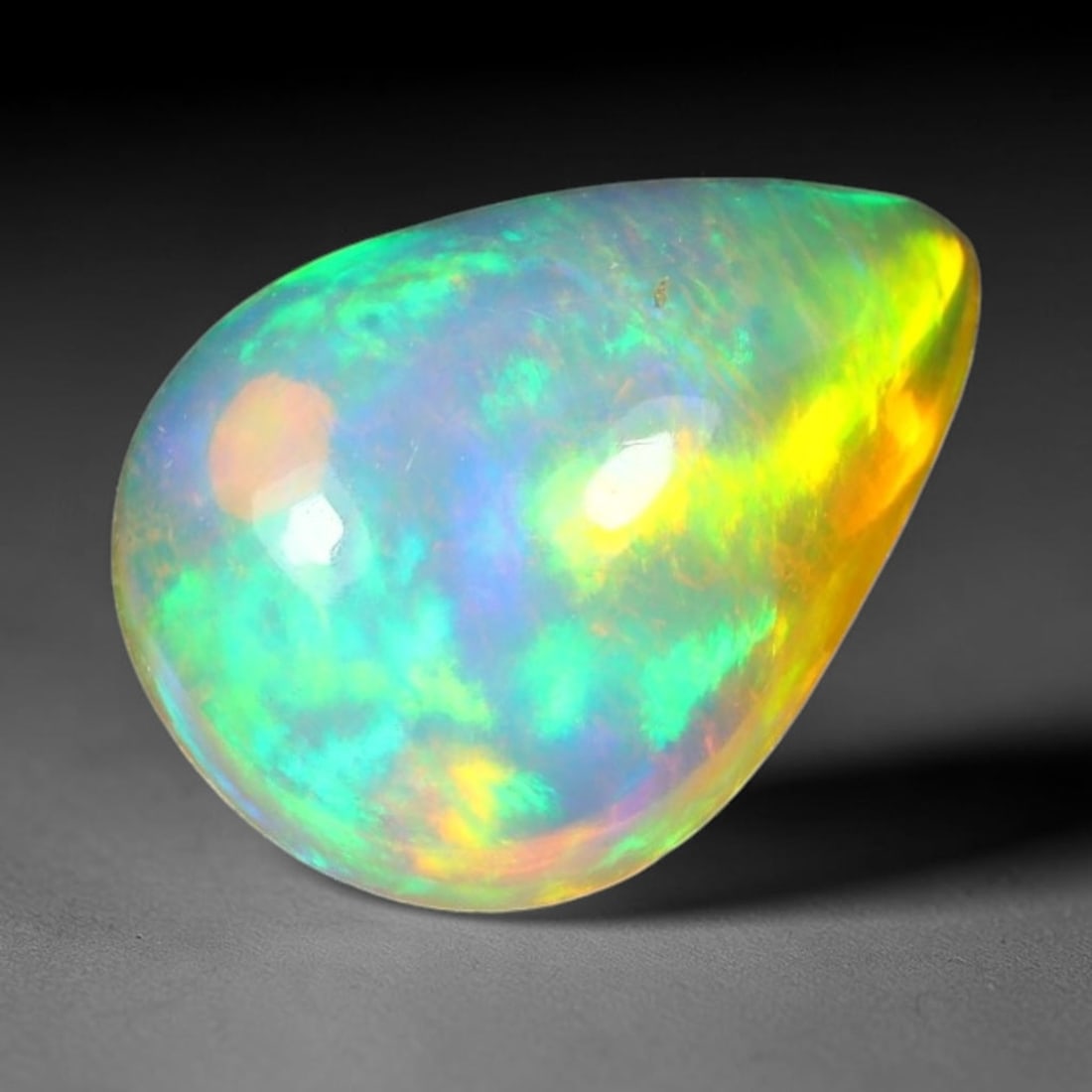 1.64ct Natural Ethiopian Welo Solid Opal Oval Cabochon Loose Gemstone, 61TG: Solid opal cabochon mined from Ethiopia's Welo opal deposits, polished into a smooth elongated oval dome with high reflective gloss. The translucent pale milky base hosts broad shifting play-of-color 