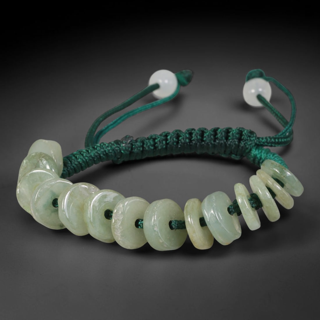 Natural Burmese Type A Pale Green Donut Jadeite Jade Adjustable Braided Bracelet, 61TA: Handcrafted from untreated natural Burmese Type A jadeite, this woven cord bracelet features graduated flat circular donut beads with the largest disc measuring 10.53 mm in thickness, exhibiting soft 