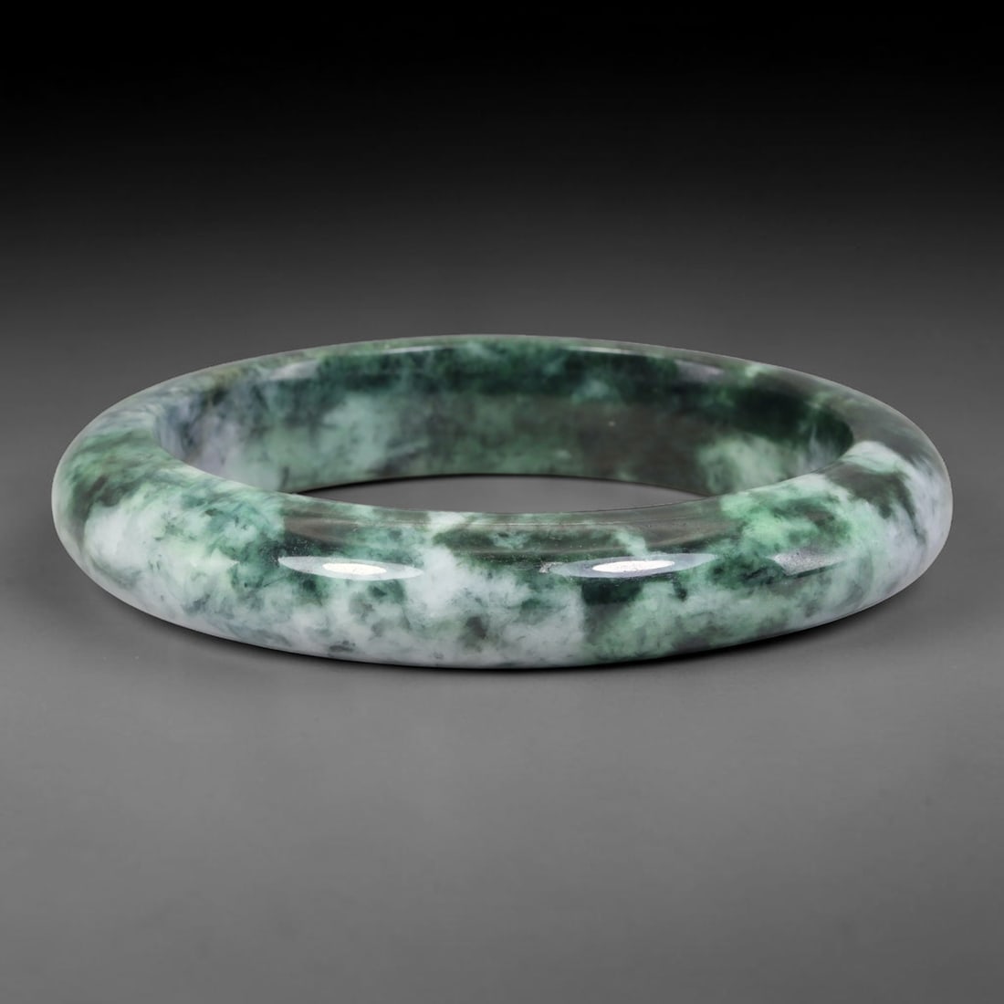Natural Burmese Type A Moss Floating Flower Green Jadeite Jade Bangle Bracelet, 65TD: Polished from natural Burmese jadeite, this solid bangle features a pale milky white base swirled with deep moss green cloud-like floating flower patterning throughout the matrix. Formed in a traditio
