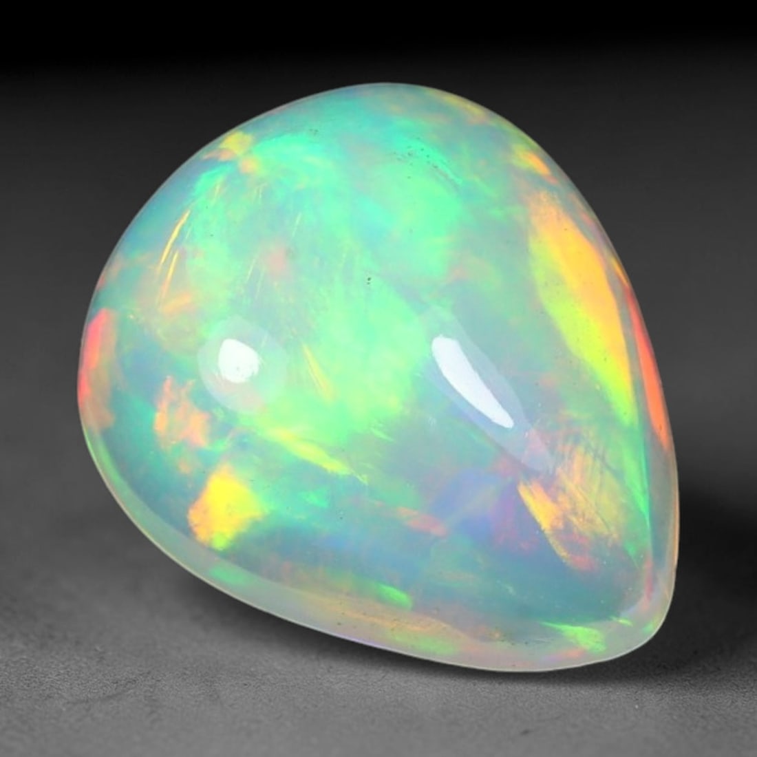 1.92ct Natural Ethiopian Welo Solid Opal Oval Cabochon Loose Gemstone, 51TG: Solid opal cabochon mined from Ethiopia's Welo opal deposits, polished into a smooth elongated oval dome with high reflective gloss. The translucent pale milky base hosts broad shifting play-of-color 