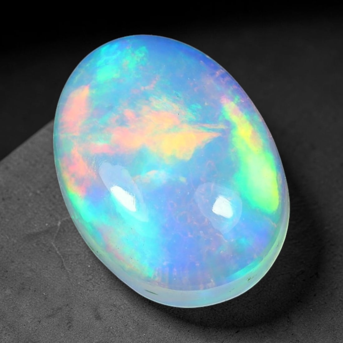 1.97ct Natural Ethiopian Welo Solid Opal Oval Cabochon Loose Gemstone, 41TG: Solid opal cabochon mined from Ethiopia's Welo opal deposits, polished into a smooth elongated oval dome with high reflective gloss. The translucent pale milky base hosts broad shifting play-of-color 