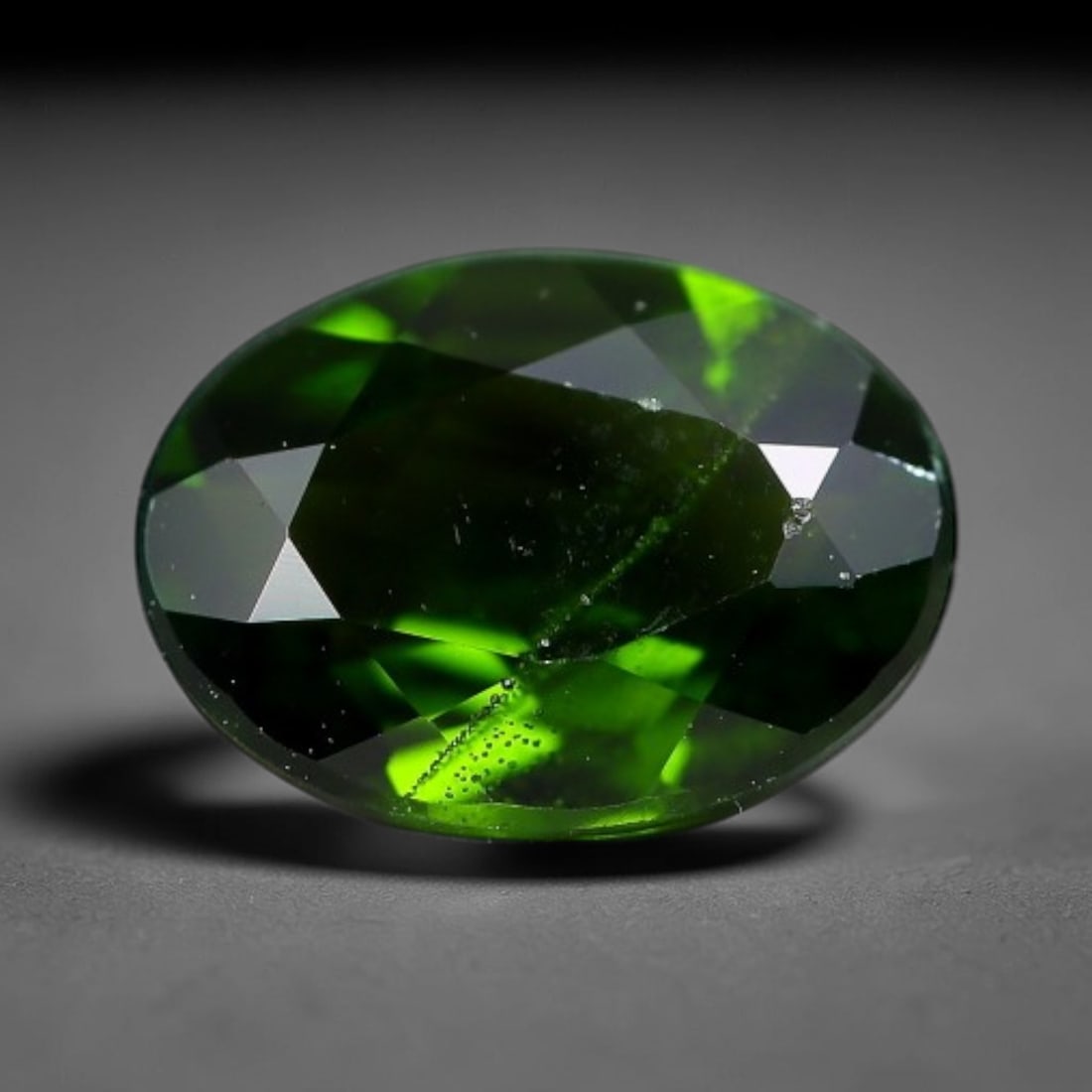 1.20 Carats Natural Vivid Chrome Green Chrome Diopside Oval Faceted Loose Gemstone, 4WJ: This striking chrome diopside faceted oval stone showcases vivid intense chrome green color illuminated through crisp polished step facets, with fine tiny natural mineral speckles visible within the t